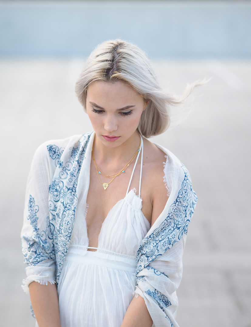 White dress and layered necklaces
